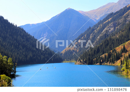Picturesque autumn scenery of Kolsai lake, Tien Shan Mountains, Kazakhstan. Tourist pastime catamaran rides on Alpine Kolsai lake, Almaty region. Topic of vacation, travel, leisure, adventure Picturesque autumn scenery of Kolsai lake, Tien Shan Mountains, Kazakhstan. Tourist pastime catamaran rides on Alpine Kolsai lake, Almaty region. Topic of vacation, travel, leisure, adventure 131898476