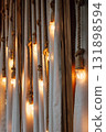 decorative lighting design featuring warm bulbs hanging from ropes against soft fabric backdrop. 131898594