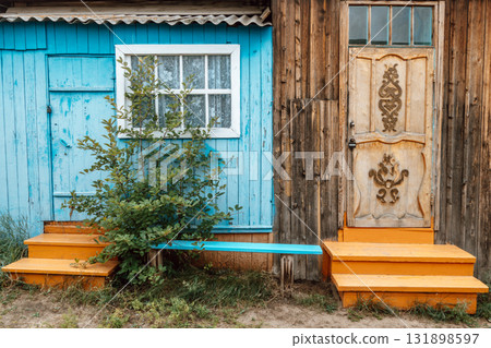 colorful wooden house facade with vibrant blue and orange steps in rural setting. closeup. colorful wooden house facade with vibrant blue and orange steps in rural setting. closeup. 131898597