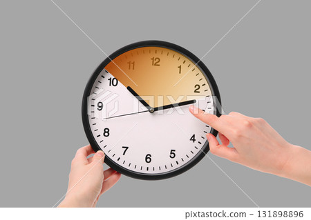 Person adjusting a clock to reflect daylight saving time changes Person adjusting a clock to reflect daylight saving time changes 131898896