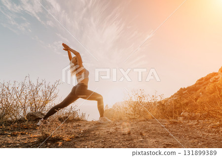 Woman Stretching on Mountain Ridge at Sunset Woman Stretching on Mountain Ridge at Sunset 131899389
