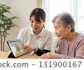 老年人和照護人員使用平板電腦進行交流 131900167