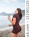 Morning workout by the sea woman refreshing with water active lifestyle and fitness promoting wellness outdoors 131901120