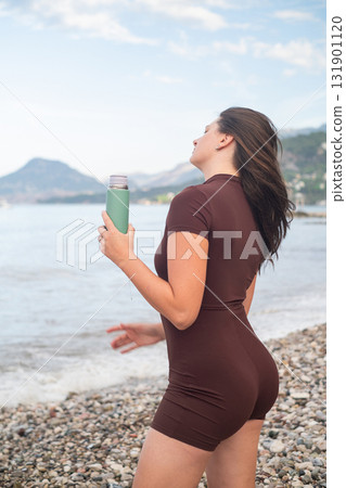 Morning workout by the sea woman refreshing with water active lifestyle and fitness promoting wellness outdoors 131901120