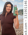 Outdoor fitness morning workout on beach hydration and energy promoting healthy active lifestyle 131901146