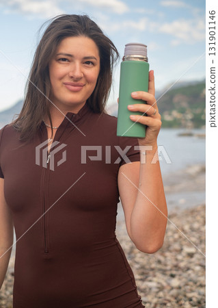 Outdoor fitness morning workout on beach hydration and energy promoting healthy active lifestyle 131901146