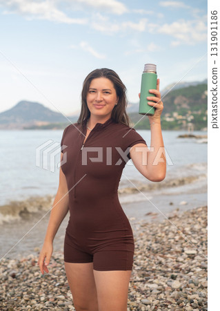 Morning workout by the sea woman drinking water fitness wellness and coastal active lifestyle outdoors Morning workout by the sea woman drinking water fitness wellness and coastal active lifestyle outdoors 131901186