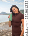 Woman enjoying peaceful seaside morning, refreshing body with water after sport activity. 131901232