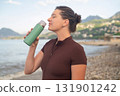 Outdoor fitness morning workout on beach hydration and energy promoting healthy active lifestyle 131901242