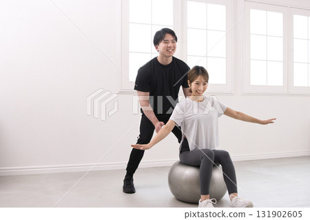 Young woman receiving lessons from a personal trainer 131902605