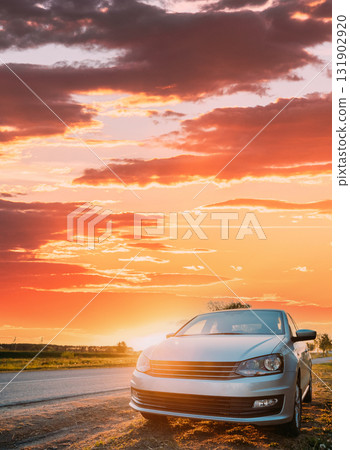 Sedan Car Parking Near Asphalt Country Road In Sunny Sunset. Sunlight Above Road In Sunrise Sedan Car Parking Near Asphalt Country Road In Sunny Sunset. Sunlight Above Road In Sunrise 131902920