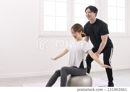 年輕女子正在接受私人教練的指導 年輕女子正在接受私人教練的指導 131903061
