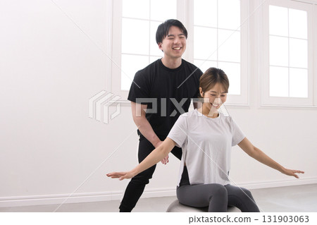 年輕女子正在接受私人教練的指導 年輕女子正在接受私人教練的指導 131903063