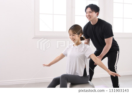 Young woman receiving lessons from a personal trainer 131903143