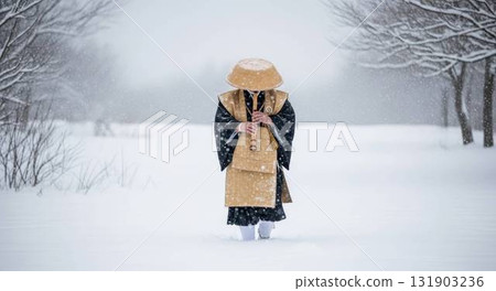 A monk walking along a snowy path with a shakuhachi in hand 131903236