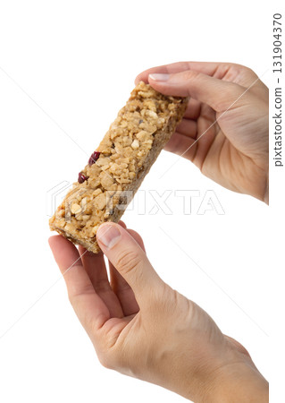 Hands holding healthy oat and nut granola bar, nutritious on-the-go snack isolated on transparent background Hands holding healthy oat and nut granola bar, nutritious on-the-go snack isolated on transparent background 131904370