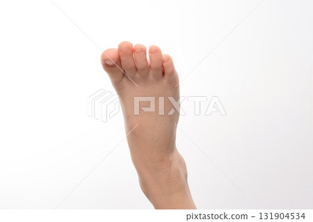 Close-up of a child's foot, toes slightly curled. Soft skin and delicate features are visible against a white background. Close-up of a child's foot, toes slightly curled. Soft skin and delicate features are visible against a white background. 131904534