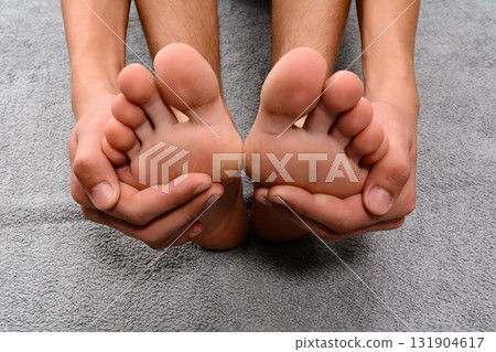 Close-up of hands gently massaging feet. Relaxation and self-care. Close-up of hands gently massaging feet. Relaxation and self-care. 131904617