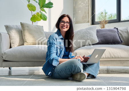 Portrait of young beautiful positive woman with laptop sitting at home Portrait of young beautiful positive woman with laptop sitting at home 131904798