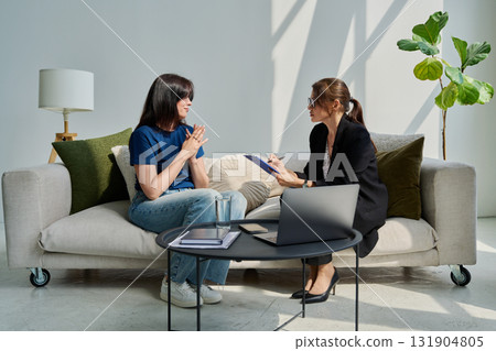 Female patient talking to psychotherapist psychologist, sitting together in office Female patient talking to psychotherapist psychologist, sitting together in office 131904805
