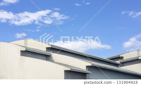 Modern industrial warehouse roof architecture with blue sky background 131904928
