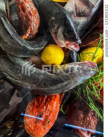 Raw fish fillet with tomatoes and herbs. Against a dark background. Seafood on ice at the fish market. Seafood. Healthy diet eating concept. View from above. 131905332