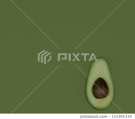 Avocado fruit half on green background. Green avocado, minimal flat lay style with copy space. Avocado fruit half on green background. Green avocado, minimal flat lay style with copy space. 131905334