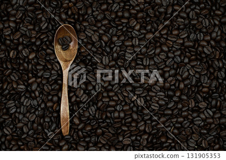 a hint of subtle taste and the ability to enjoy the taste of coffee alone or with friends, these coffee beans are on spoons and scattered on the surface as a background 131905353