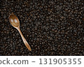 a hint of subtle taste and the ability to enjoy the taste of coffee alone or with friends, these coffee beans are on spoons and scattered on the surface as a background 131905355