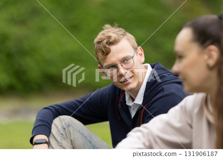 Young man smiling and talking with friend in nature 131906187