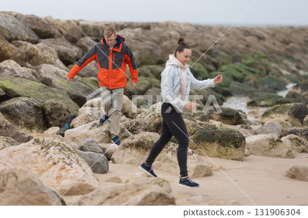 Young couple exploring rocky beach coastline 131906304