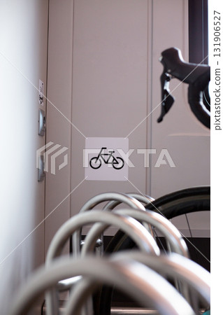 Designated area for bicycles on train. Bike rack with clear, simple bike symbol indicating space. Image conveys modern, convenient space for cyclists in public transportation 131906527