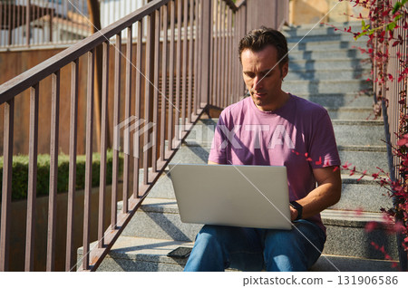 Man Working On Laptop Outdoors On Steps, Casual Remote Work 131906586