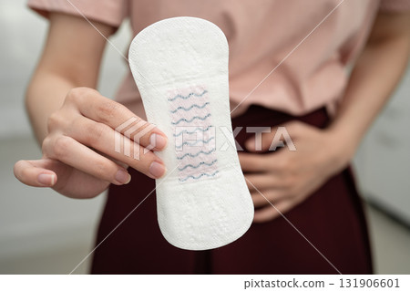 Asian woman holding sanitary napkin pad for hygiene menstrual period cycle protection. Asian woman holding sanitary napkin pad for hygiene menstrual period cycle protection. 131906601