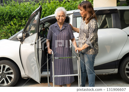 Caregiver help Asian elderly woman disability patient get in her car. Caregiver help Asian elderly woman disability patient get in her car. 131906607