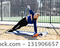 Sportswoman performing side plank exercise outdoors 131906657