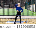 Confident sportswoman posing with resistance band on a sports field 131906658