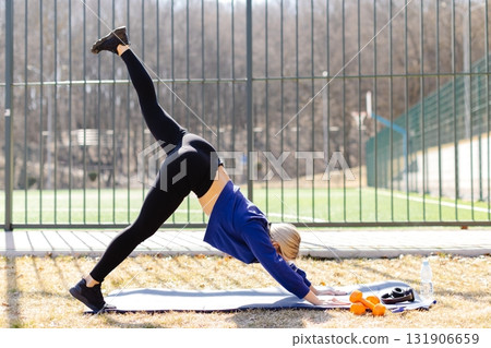 Athletic woman practicing three legged down dog pose increasing flexibility 131906659