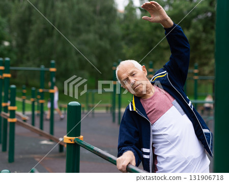 Mature man practice on the sports ground equipment in park 131906718