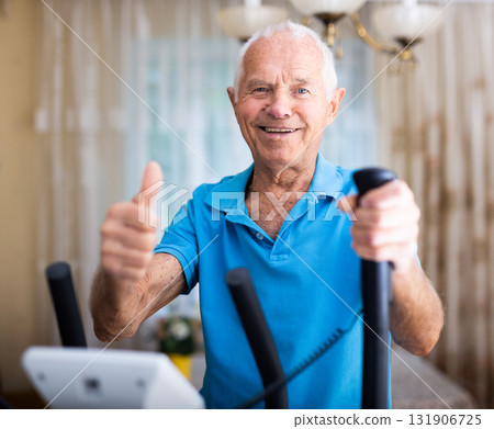 Senior man with elliptical trainer at home Senior man with elliptical trainer at home 131906725