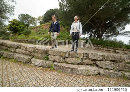 Young couple walking together on path in park Young couple walking together on path in park 131906726
