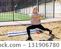 Young woman stretching legs practicing yoga asana outdoors in the park 131906780