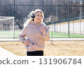 Young sporty woman jogging while listening to music with headphones in a sports center 131906784