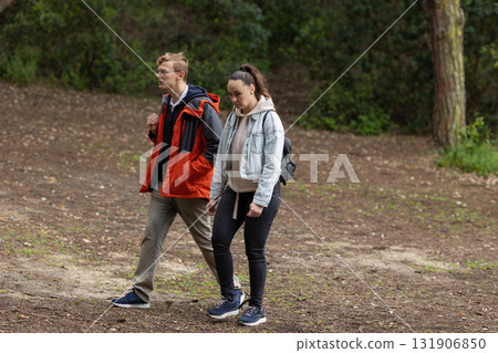Young couple walking outdoors enjoying nature trail 131906850