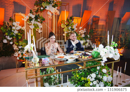 The bride and groom listen to congratulations and toasts from guests 131906875