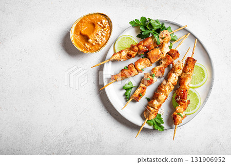 Malaysian chicken satay skewers with peanut sauce 131906952