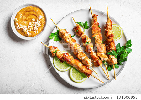Malaysian chicken satay skewers with peanut sauce 131906953