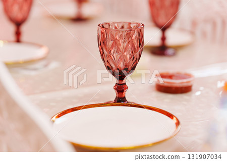 Elegant red glass and empty plates set for a special dinner gathering 131907034