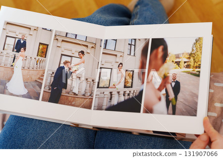 Female hands flipping through a photo book with wedding photos Female hands flipping through a photo book with wedding photos 131907066