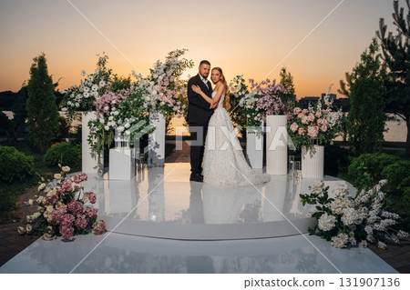 Gentle and happy bride and groom at sunset on the riverbank. Romantic. 131907136